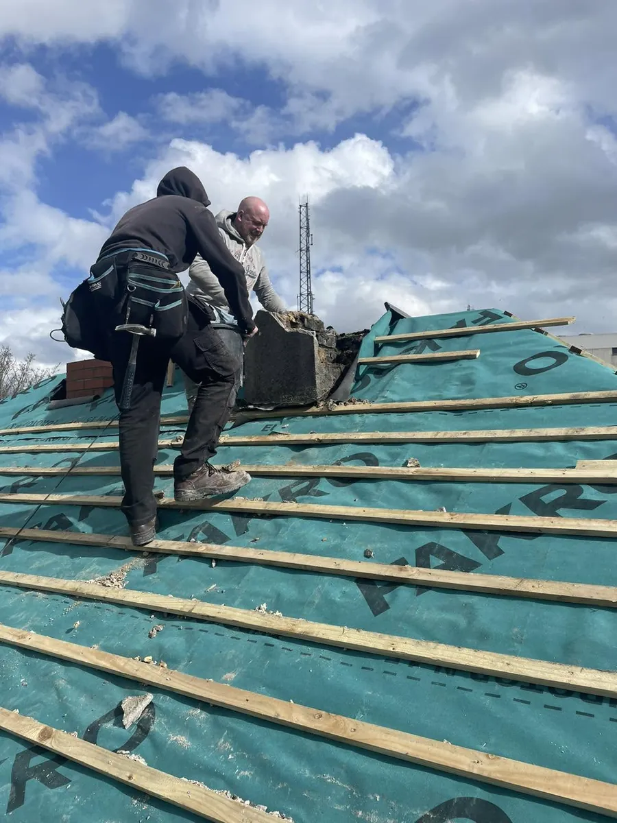 Roofer laying new slates over breathable membrane, Flaherty Roof and Driveways