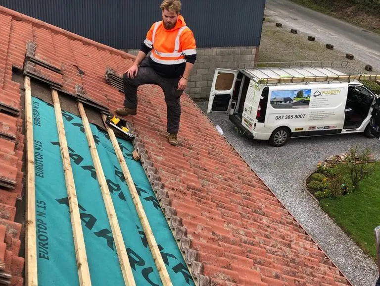 Roofer on new membrane and battens with the Flaherty van below, Flaherty Roof and Driveways