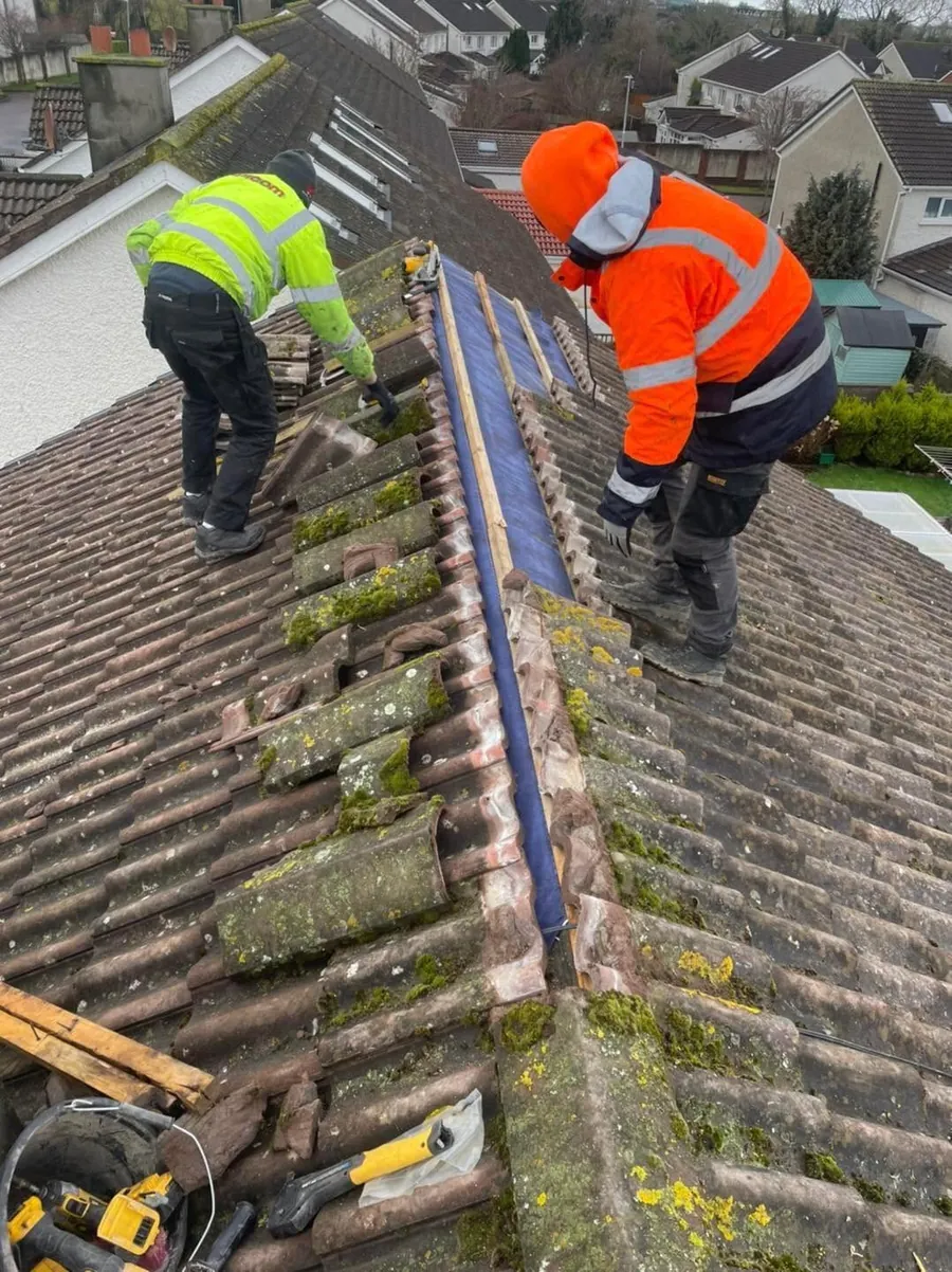 Two roofers in hi-vis stripping a concrete tile roof, Flaherty Roof and Driveways
